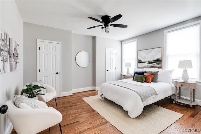 bedroom featuring ceiling fan, baseboards, and wood finished floors