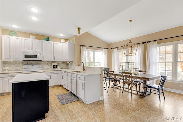 kitchen featuring white appliances, light countertops, tasteful backsplash, and a sink