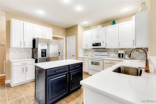 kitchen with a sink, a kitchen island, white cabinets, white appliances, and dark cabinets