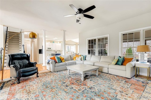 living room with stairs, vaulted ceiling, a ceiling fan, and ornate columns