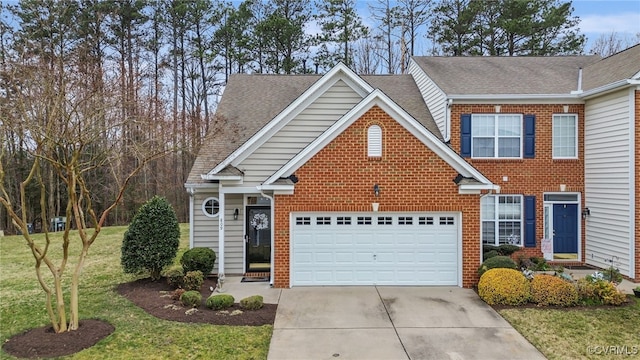 view of front of property featuring a front yard, brick siding, driveway, and a shingled roof