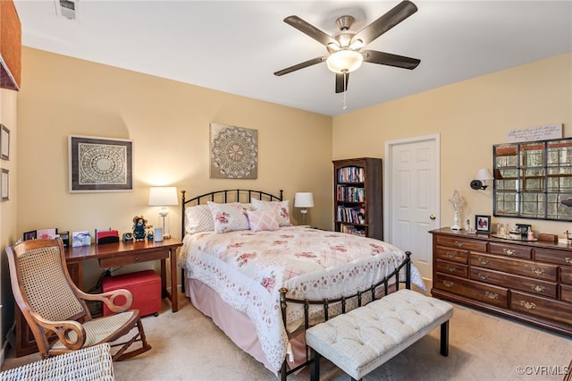 bedroom with visible vents, light colored carpet, and ceiling fan