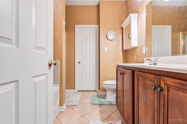 full bath with vanity, a tub to relax in, baseboards, tile patterned floors, and toilet