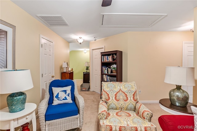 sitting room featuring visible vents, baseboards, carpet, and attic access