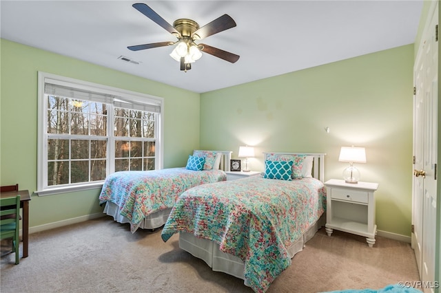 carpeted bedroom featuring visible vents, baseboards, and ceiling fan