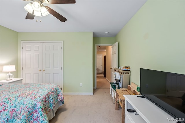 bedroom with ceiling fan, baseboards, a closet, and light carpet