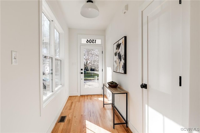 entryway featuring baseboards, visible vents, and light wood finished floors