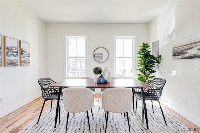 dining area with a healthy amount of sunlight, light wood-type flooring, and baseboards