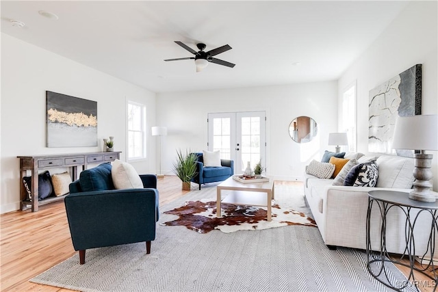 living area featuring wood finished floors, french doors, baseboards, and ceiling fan