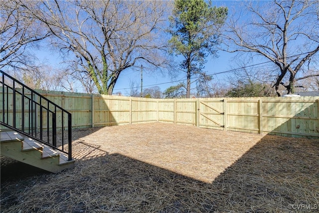 view of yard with a fenced backyard and a gate