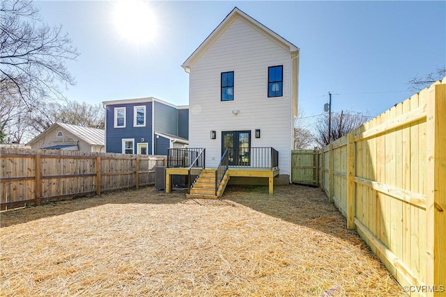 rear view of house featuring a fenced backyard and a deck