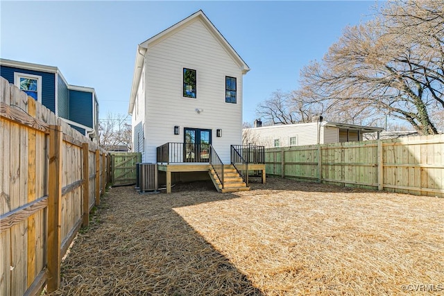 rear view of property with a fenced backyard, french doors, and a deck