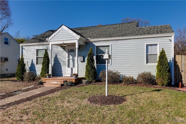 view of front of property featuring a shingled roof, a front yard, and fence