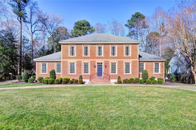 view of front of house with brick siding and a front yard