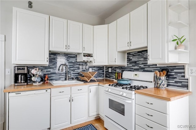 kitchen featuring white appliances, open shelves, a sink, light countertops, and white cabinets