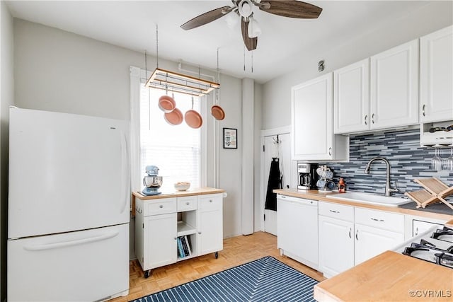 kitchen with a sink, tasteful backsplash, white cabinetry, white appliances, and ceiling fan