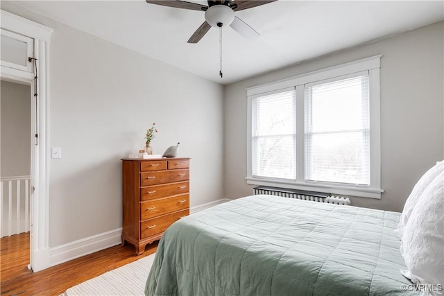 bedroom featuring a ceiling fan, baseboards, and wood finished floors