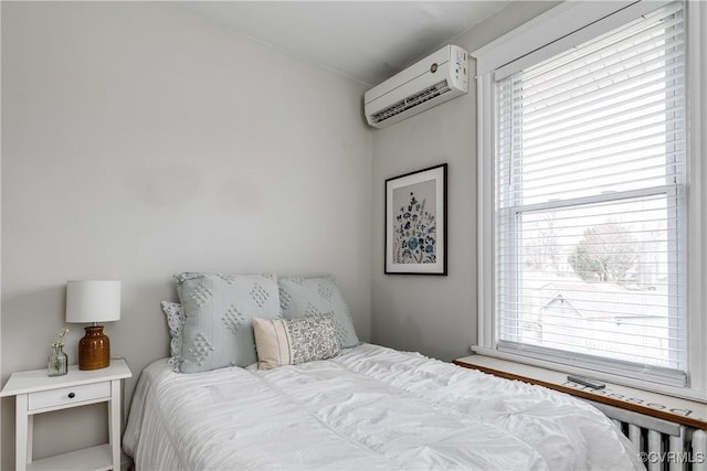 bedroom featuring multiple windows and a wall mounted AC