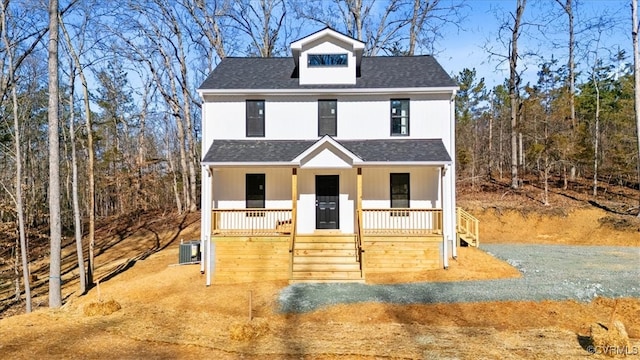 view of front facade with cooling unit, a porch, and a shingled roof