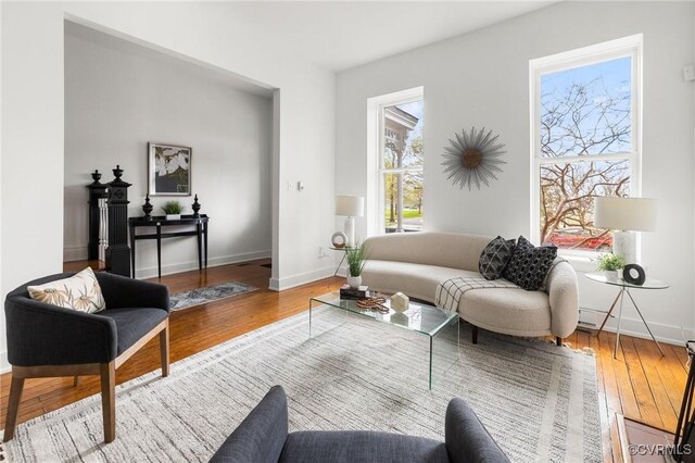 living area featuring baseboards and hardwood / wood-style flooring