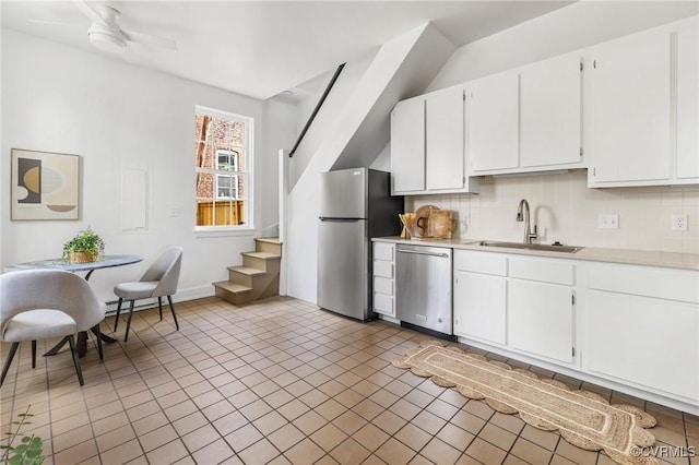 kitchen with stainless steel appliances, backsplash, light countertops, and a sink