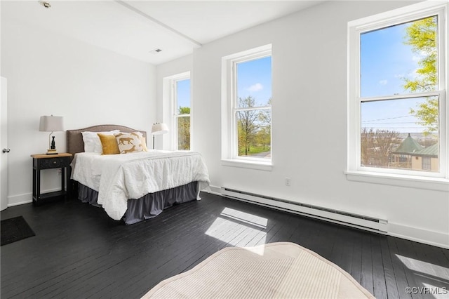 bedroom featuring a baseboard radiator, visible vents, and dark wood finished floors
