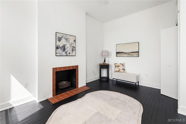 bedroom featuring wood-type flooring, a fireplace, and baseboards