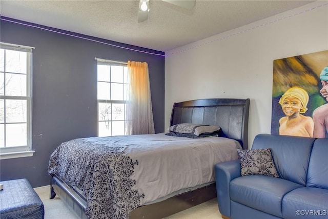 carpeted bedroom featuring a textured ceiling and ceiling fan