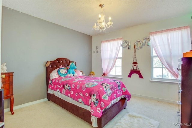 carpeted bedroom with baseboards and a chandelier