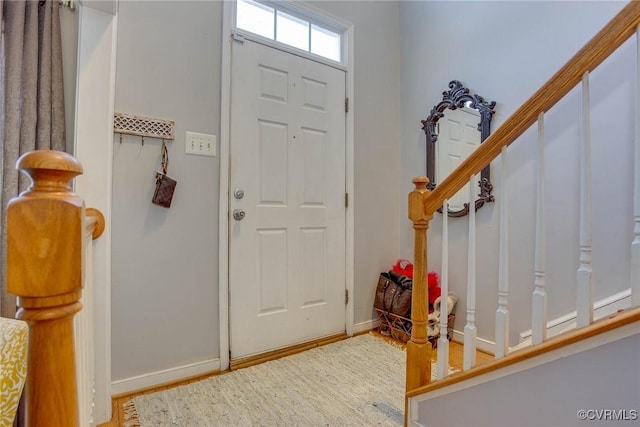 entryway featuring stairway, baseboards, and wood finished floors