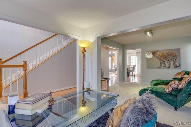 living room featuring stairs, baseboards, and carpet floors