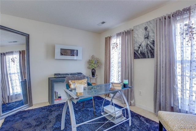 office space featuring baseboards and visible vents