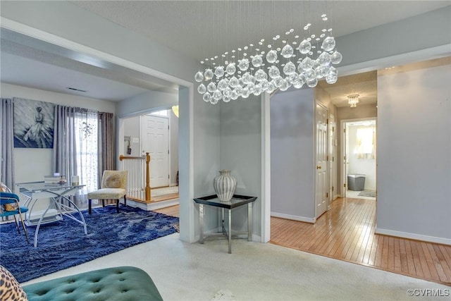 entrance foyer featuring baseboards, wood-type flooring, and carpet