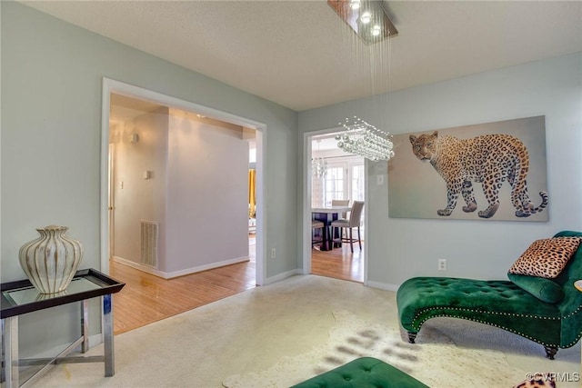 living area featuring visible vents, baseboards, and carpet