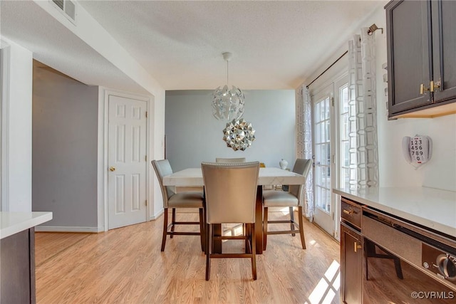 dining room with light wood finished floors, plenty of natural light, baseboards, and visible vents