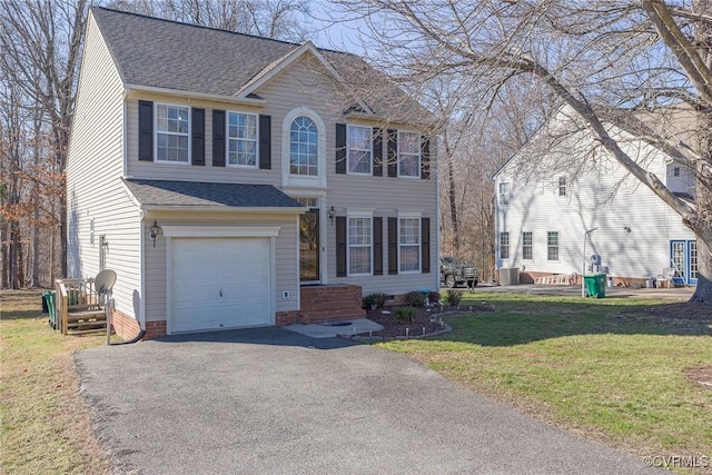 colonial-style house with roof with shingles, a front lawn, a garage, crawl space, and aphalt driveway