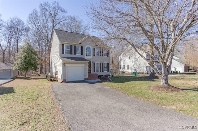 colonial-style house featuring driveway, an attached garage, a front lawn, and a shingled roof