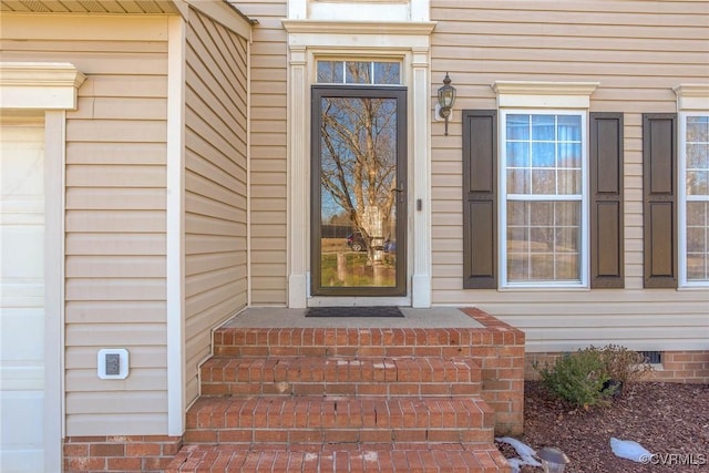 entrance to property featuring crawl space and a garage