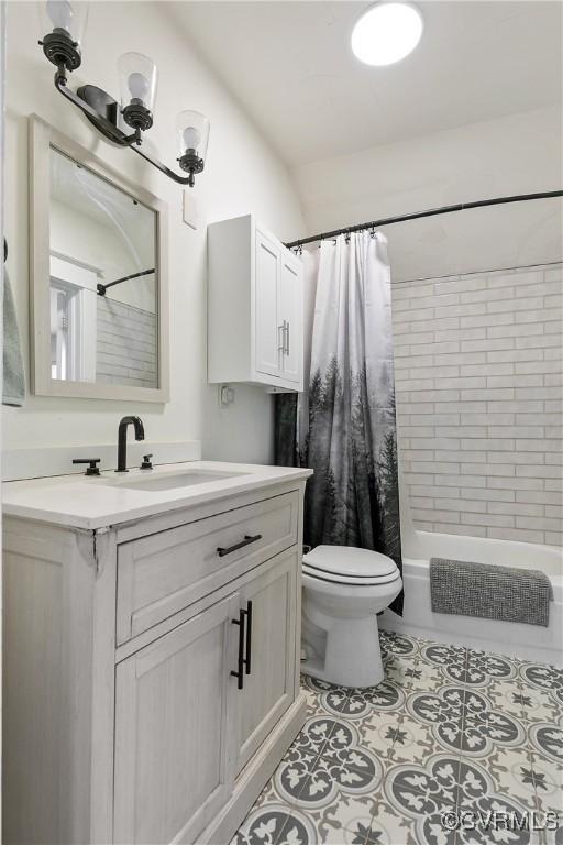 full bathroom with tile patterned flooring, shower / bath combination with curtain, toilet, and vanity