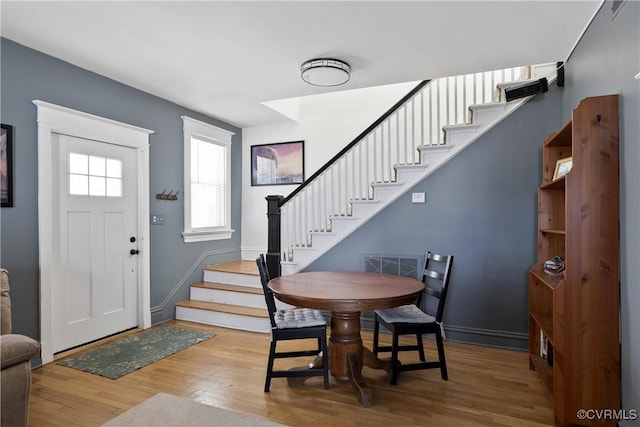 entrance foyer with stairway, wood finished floors, and baseboards