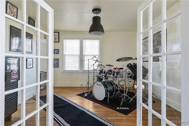 exercise room featuring french doors, baseboards, and wood finished floors