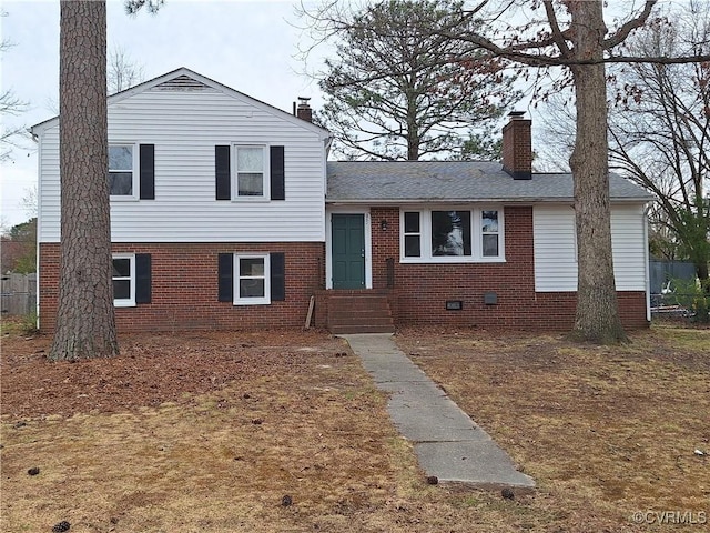 tri-level home featuring crawl space, brick siding, and a chimney