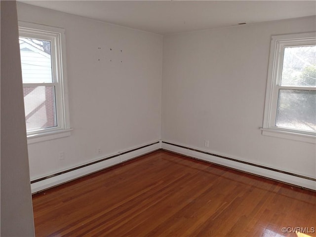 empty room with a baseboard radiator and wood finished floors