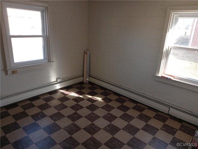 spare room with a baseboard heating unit and dark floors