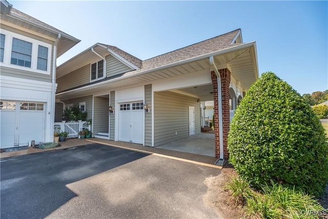 view of home's exterior featuring aphalt driveway, a shingled roof, and fence