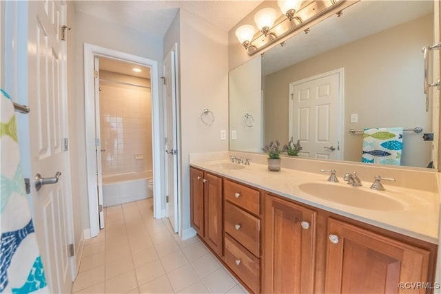 full bath with tile patterned flooring, double vanity, toilet, and a sink