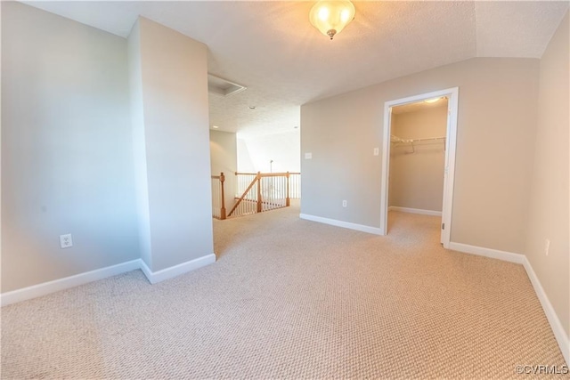 spare room featuring carpet, baseboards, and a textured ceiling