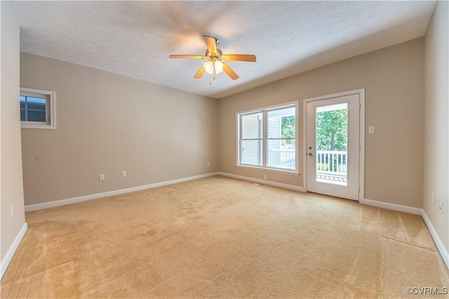 unfurnished room with baseboards, light carpet, and a textured ceiling