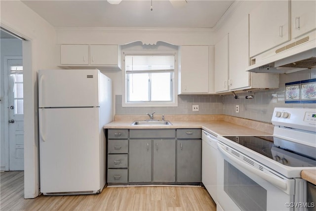 kitchen featuring under cabinet range hood, decorative backsplash, white appliances, white cabinetry, and a sink