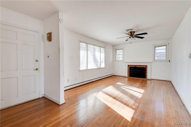 unfurnished living room featuring a baseboard radiator, a brick fireplace, and light wood-style flooring